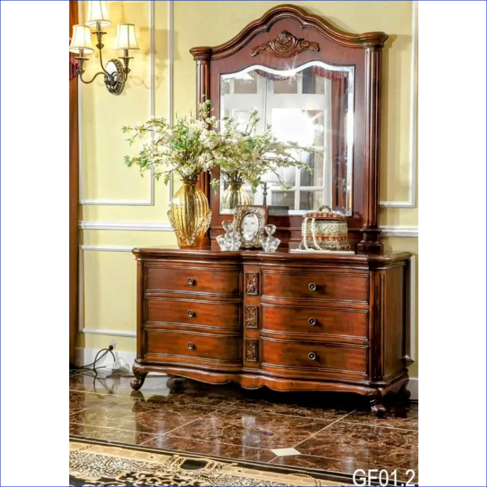 Ornate wooden dresser with mirror and decorative carved details.