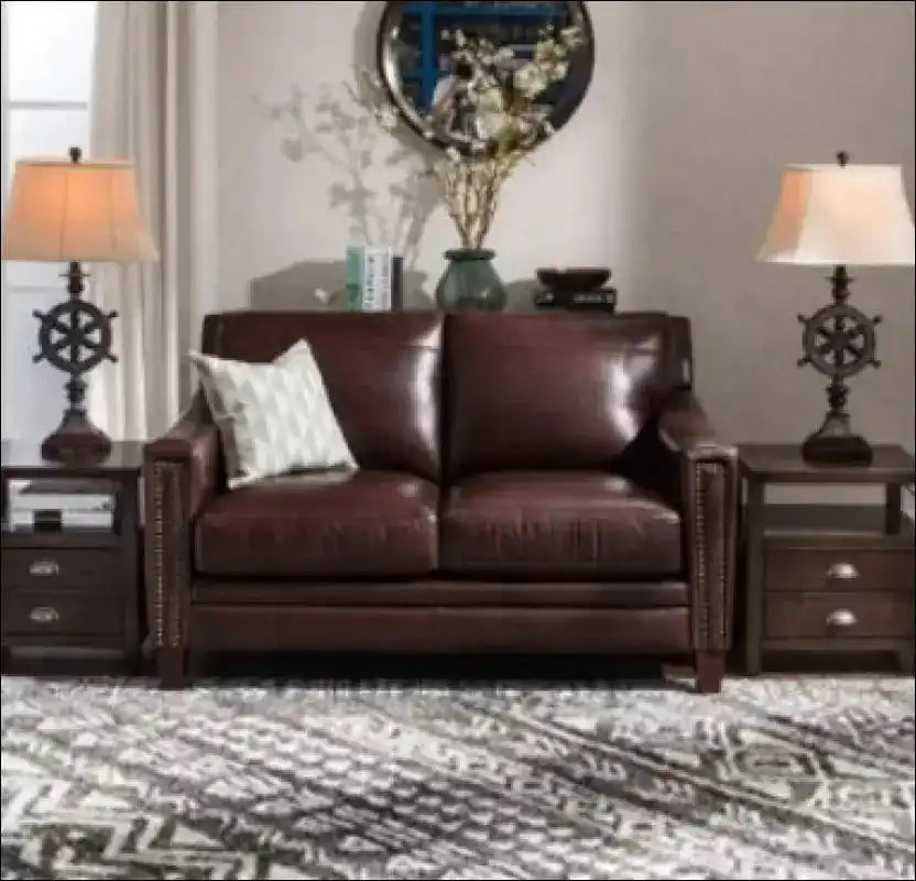 Brown leather loveseat with nailhead trim.