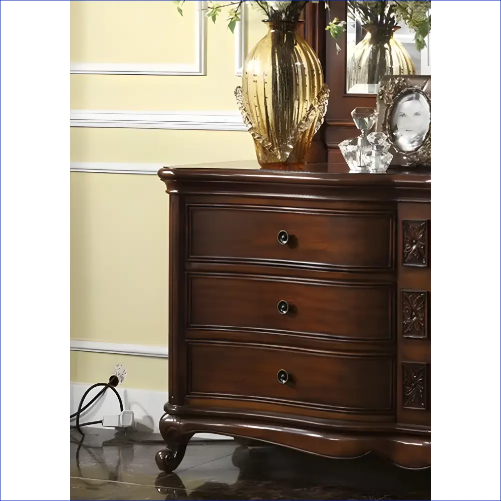 Dark wooden dresser with three drawers and ornate curved legs.