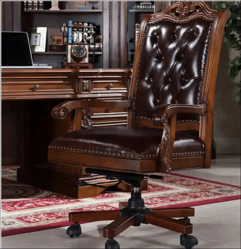 Ornate brown leather executive desk chair with tufted upholstery and carved wooden details.