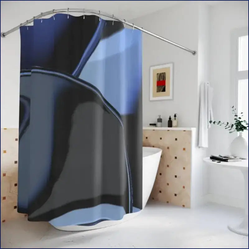 Abstract blue and black patterned shower curtain hanging from a curved rod.